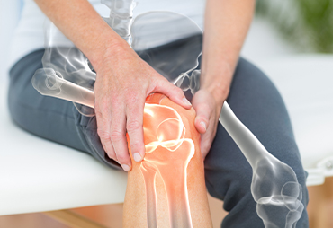 Woman holding her knee in pain from osteoarthritis